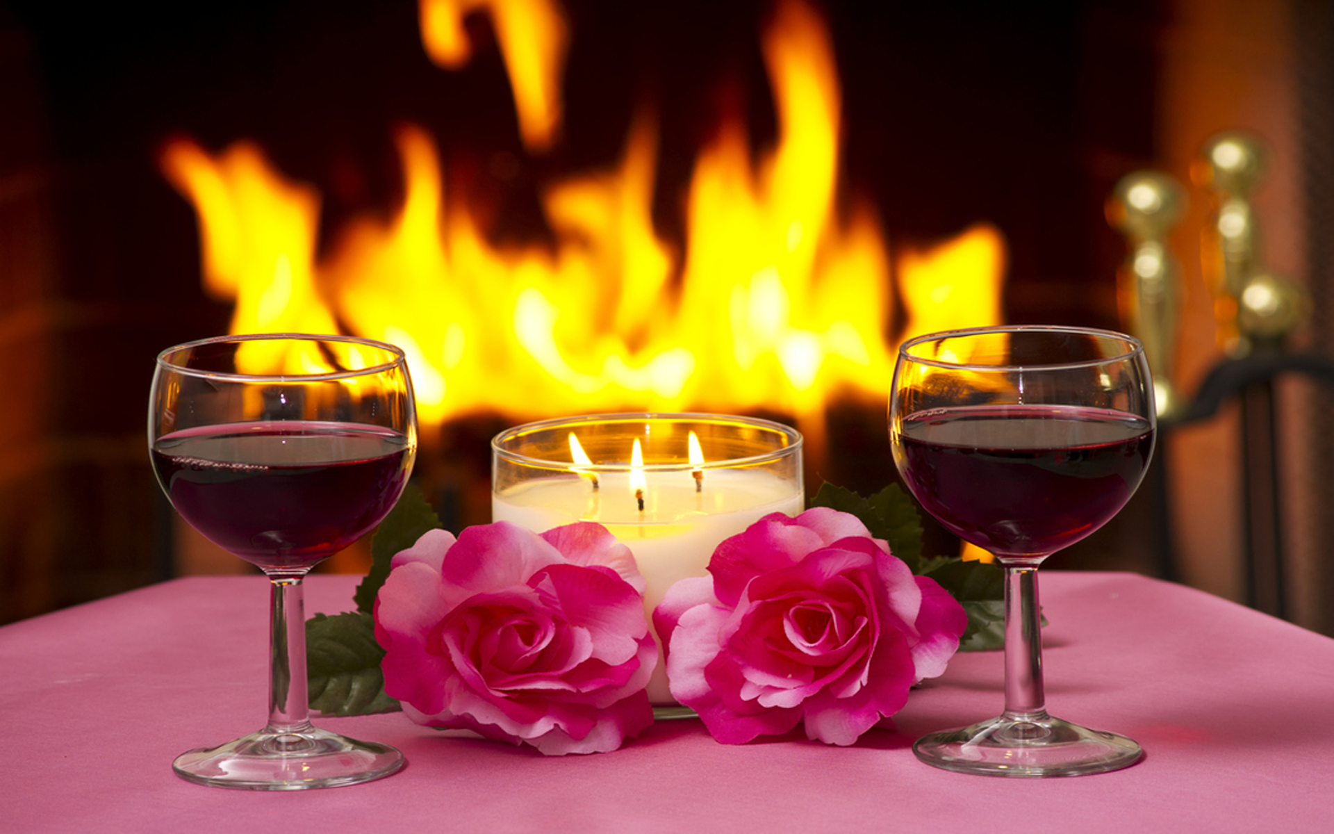 Massa two pink roses lamp lit candles two glasses of red wine a fireplace with a fire lit romantic evening for two Wallpaper HD for mobile phone