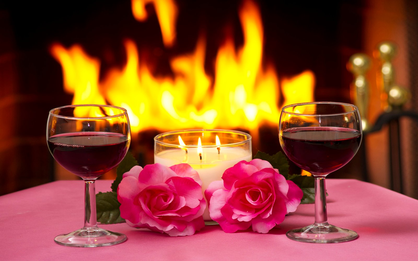 Massa two pink roses lamp lit candles two glasses of red wine a fireplace with a fire lit romantic evening for two Wallpaper HD for mobile phone